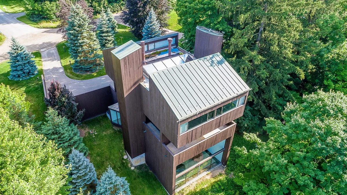 Aerial drone photo of a wooded modern home in Southeast Michigan
